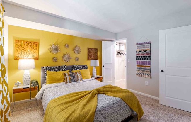 A bedroom with a bed covered in a yellow blanket.