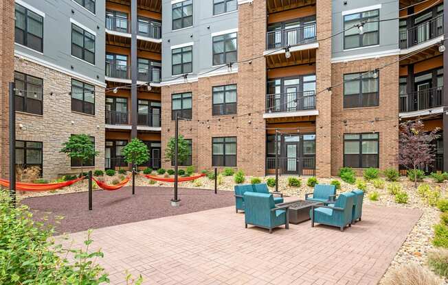 A courtyard with a brick floor and a table surrounded by chairs.