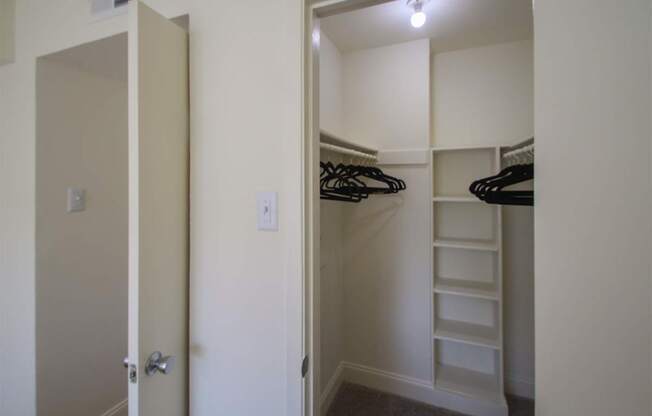 This is a photo of the bedroom walk-in closet in the 558 square foot 1 bedroom, 1 bath model apartment at The Summit at Midtown Apartments in Dallas, TX.