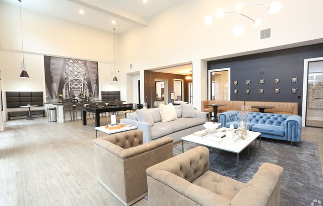 a living room with couches and chairs and a dining room with a table at Century Baxter Avenue, Louisville, KY