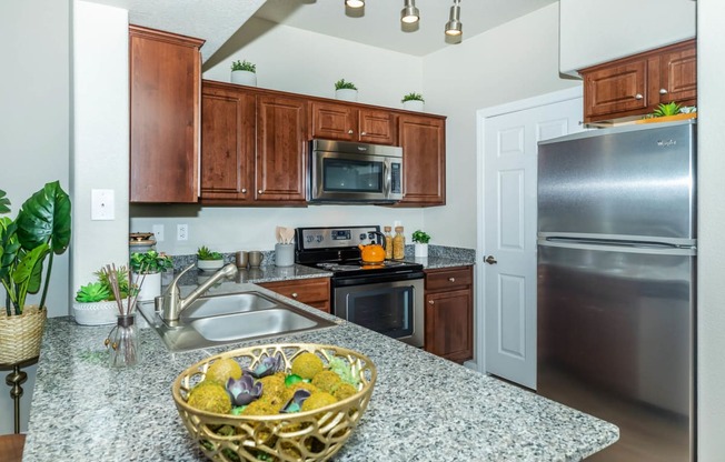 Wooden cabinets and appliances in kitchen at The Equestrian by Picerne, Henderson, NV