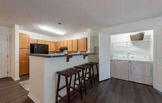 A kitchen with a white fridge and wooden cabinets.