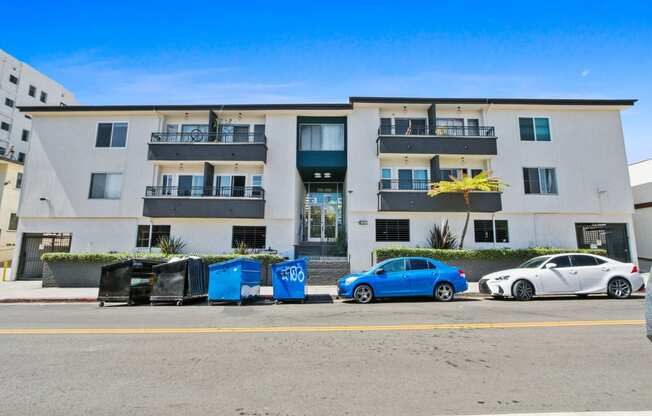 an image of an apartment building with cars parked in front