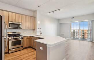 A kitchen with a refrigerator, oven, and microwave.