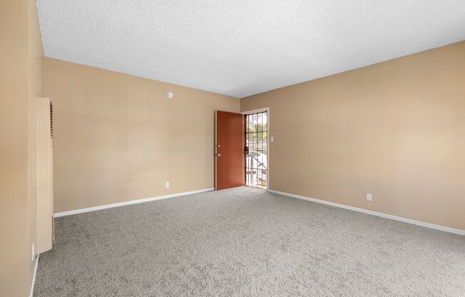 an empty bedroom with a door leading to a patio