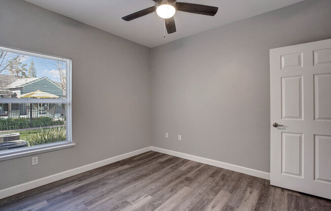 a bedroom with a ceiling fan and a window