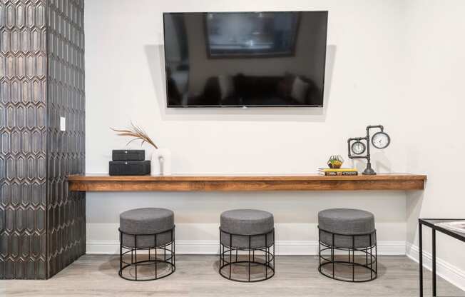 a room with a television and three stools