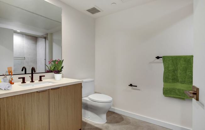 a bathroom with white walls and a green towel