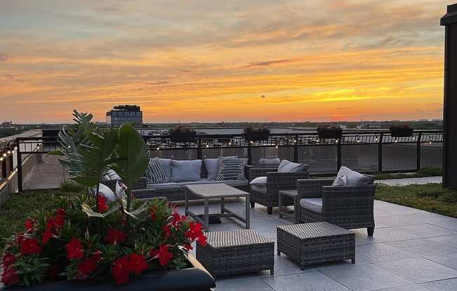 the rooftop terrace at sunset overlooking the ocean and the city skyline