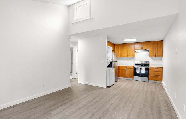 Living room with view of the kitchen with wooden cabinets and a white refrigerator.