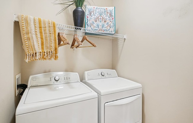 Two white washing machines in a laundry room.