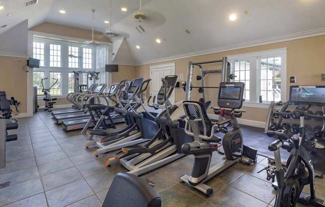 A gym with treadmills, exercise bikes, and other equipment.