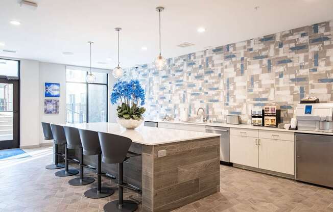 A kitchen with a long island and bar stools.
