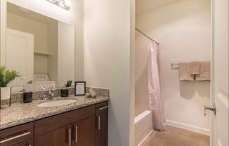 A bathroom with a sink, mirror, and towel rack at Riverplace Apartment Homes, Independence, 97351
