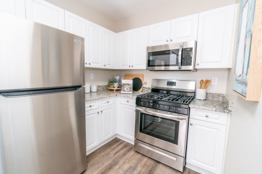 a kitchen with stainless steel appliances and white cabinets