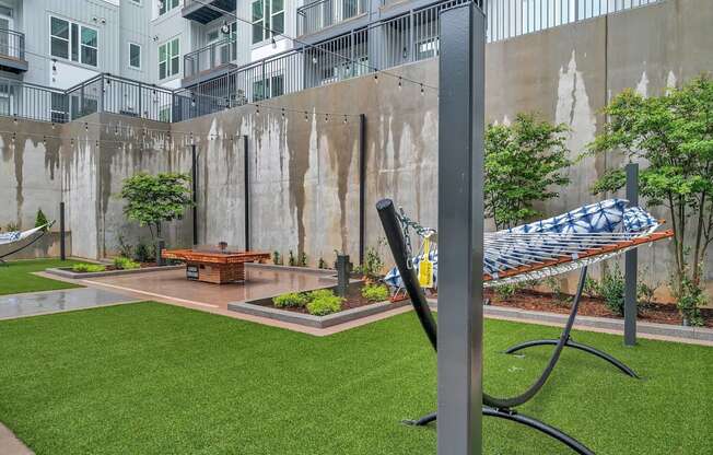 a hammock in a courtyard with a fire pit