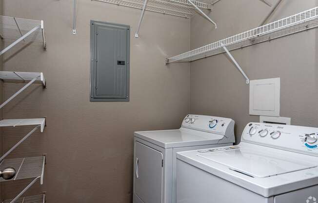 a laundry room with two washes and a dryer in it and a closet
