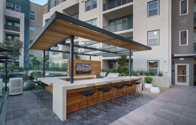 a patio with a bar and a large building in the background at NoMa Apartments, California