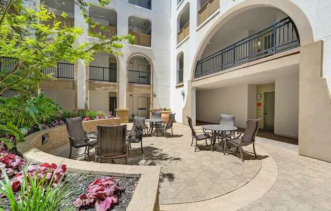A courtyard with tables and chairs and a fountain.
