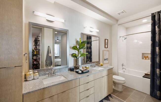 a bathroom with two sinks and a shower and a toilet