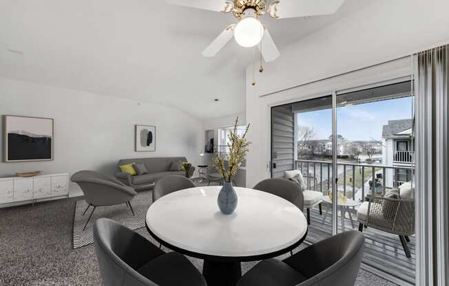 a living room with a table and chairs and a balcony