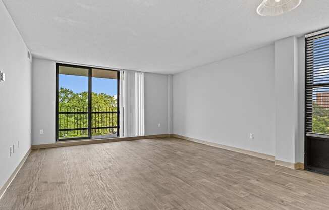 an empty living room with wood flooring and a window