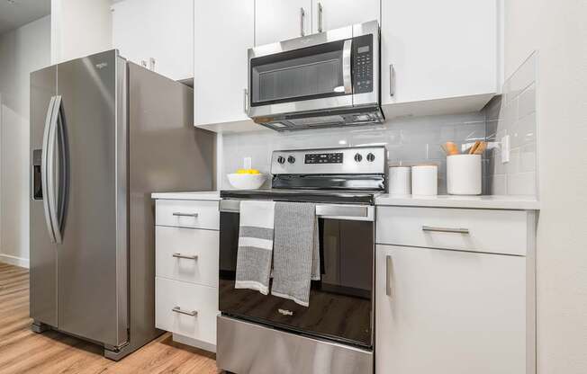 a kitchen with white cabinets and stainless steel appliances