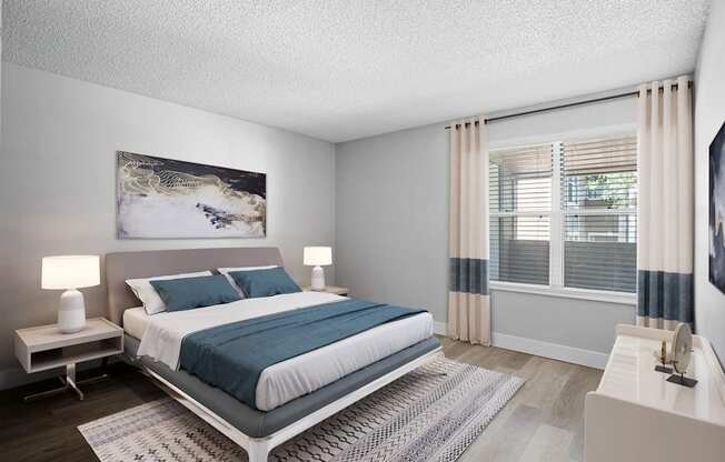 A bedroom with a large bed and a painting on the wall.