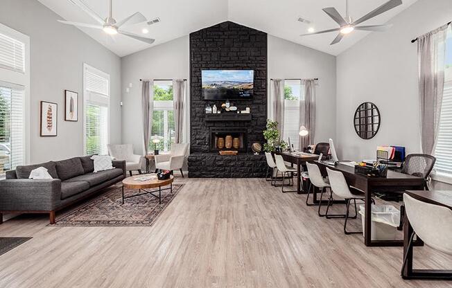A living room with a fireplace and a grey couch.