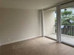 an empty living room with sliding glass doors to a balcony