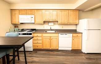 A kitchen with wooden cabinets and white appliances.