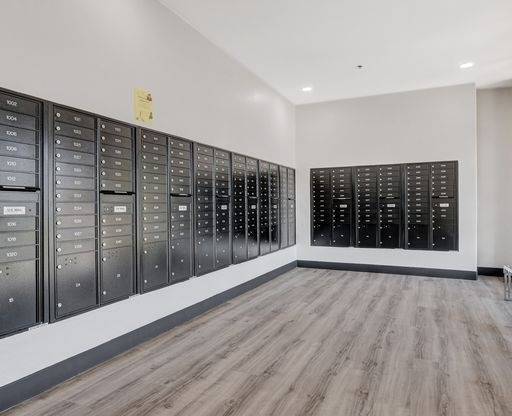 A room with a long row of mailboxes on the wall.