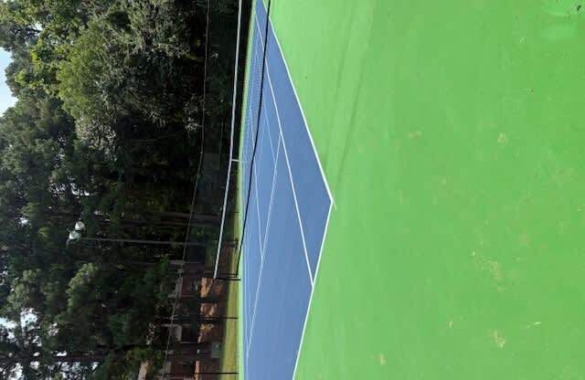 A tennis court with a blue and green surface.