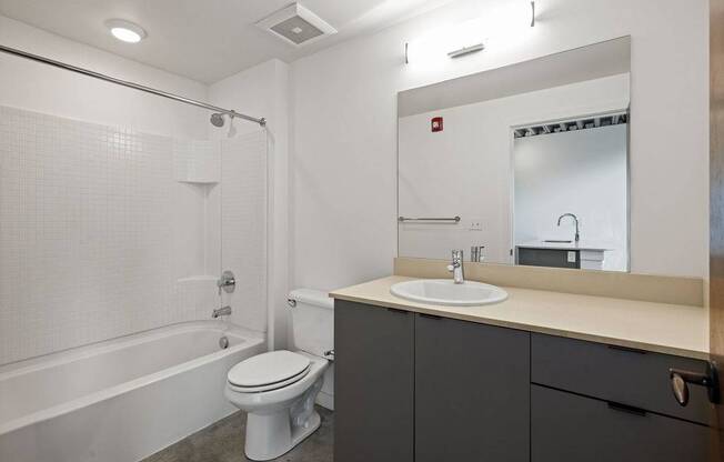 A white toilet sits next to a bathtub in a bathroom.