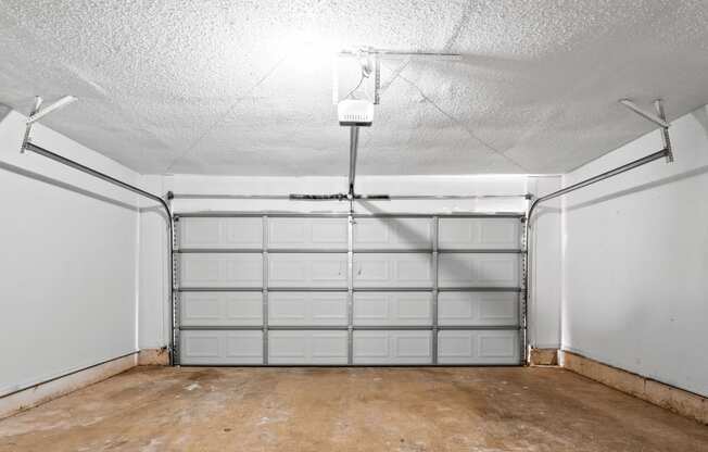 the inside of a garage with white walls and a concrete floor at Diamond Ridge Townhomes, Oklahoma