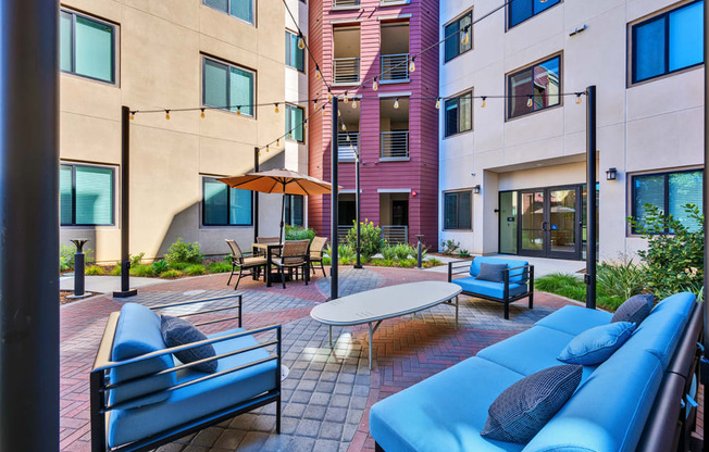 A patio with blue couches and a table.