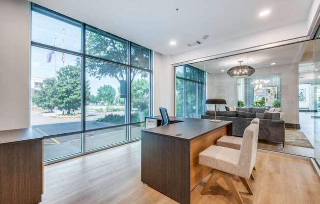 a home office with a large window overlooking a living room