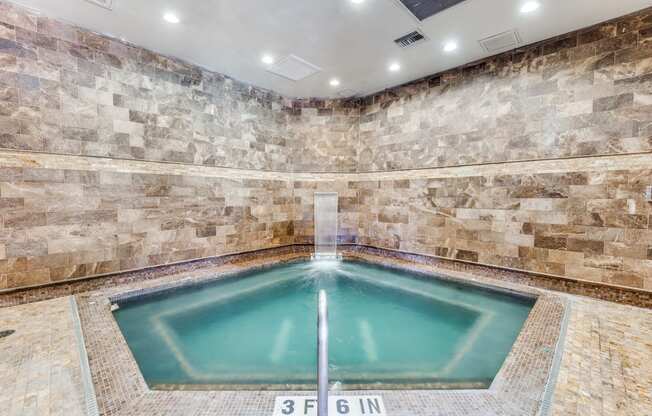 a large pool of water in a spa with stone walls