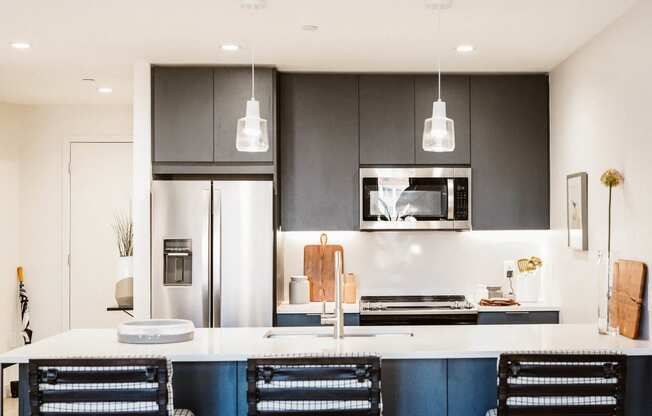 a modern kitchen with black and white cabinets and a white counter top at The Lively, Jersey City