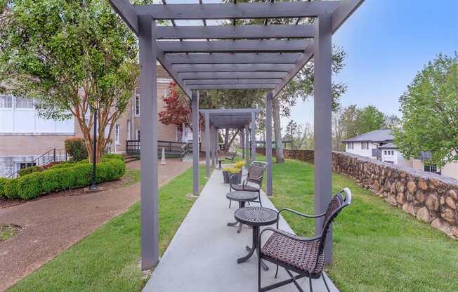 A patio with a table and chairs under a pergola.