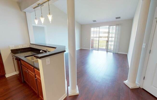A kitchen with wooden floors and white walls.
