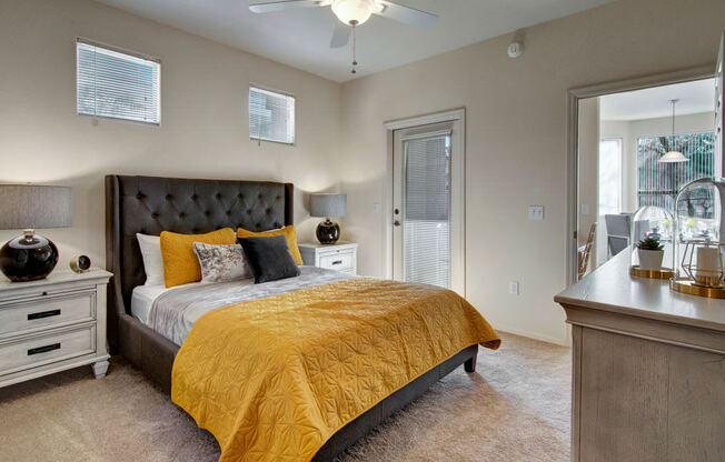A bedroom with a bed, dresser, and ceiling fan.