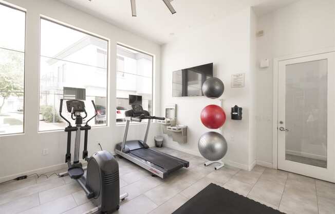 a home gym with a treadmill and exercise balls