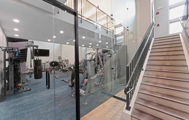 A gym with a staircase and exercise equipment.