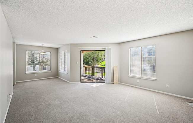 an empty living room with a door to a balcony