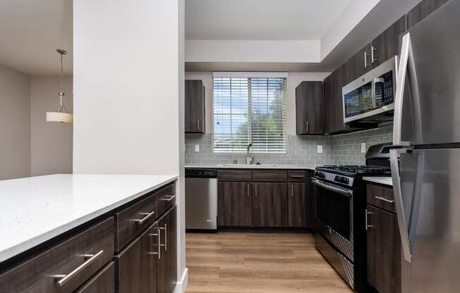 an updated kitchen with stainless steel appliances and wooden cabinets