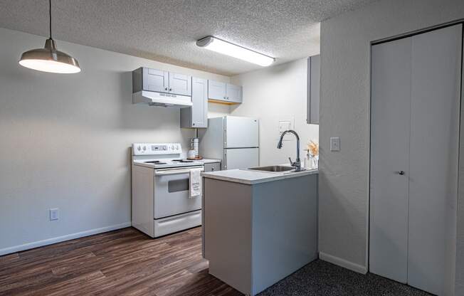 The Willows Apartments kitchen with white appliances and a sink and a refrigerator