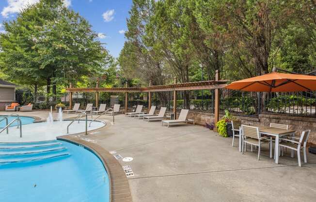 a resort style pool with chairs and tables and umbrellas