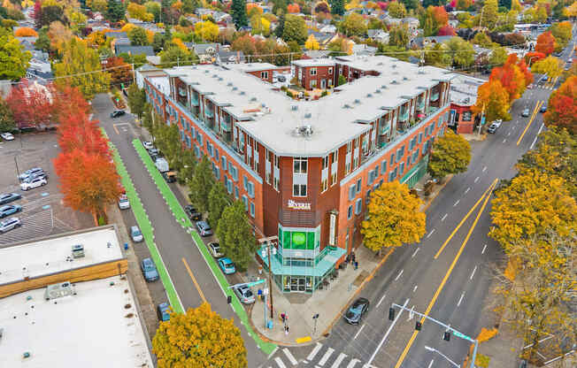 An aerial view of a street with a red brick building on the corner.