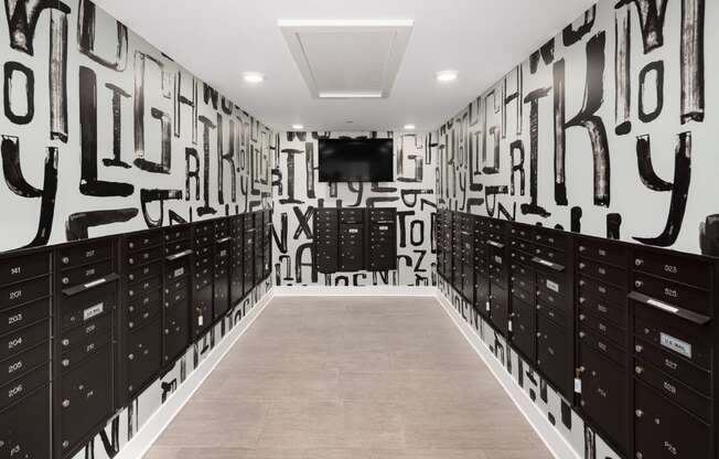 a hallway with lockers and a television in a room with graffiti on the wall